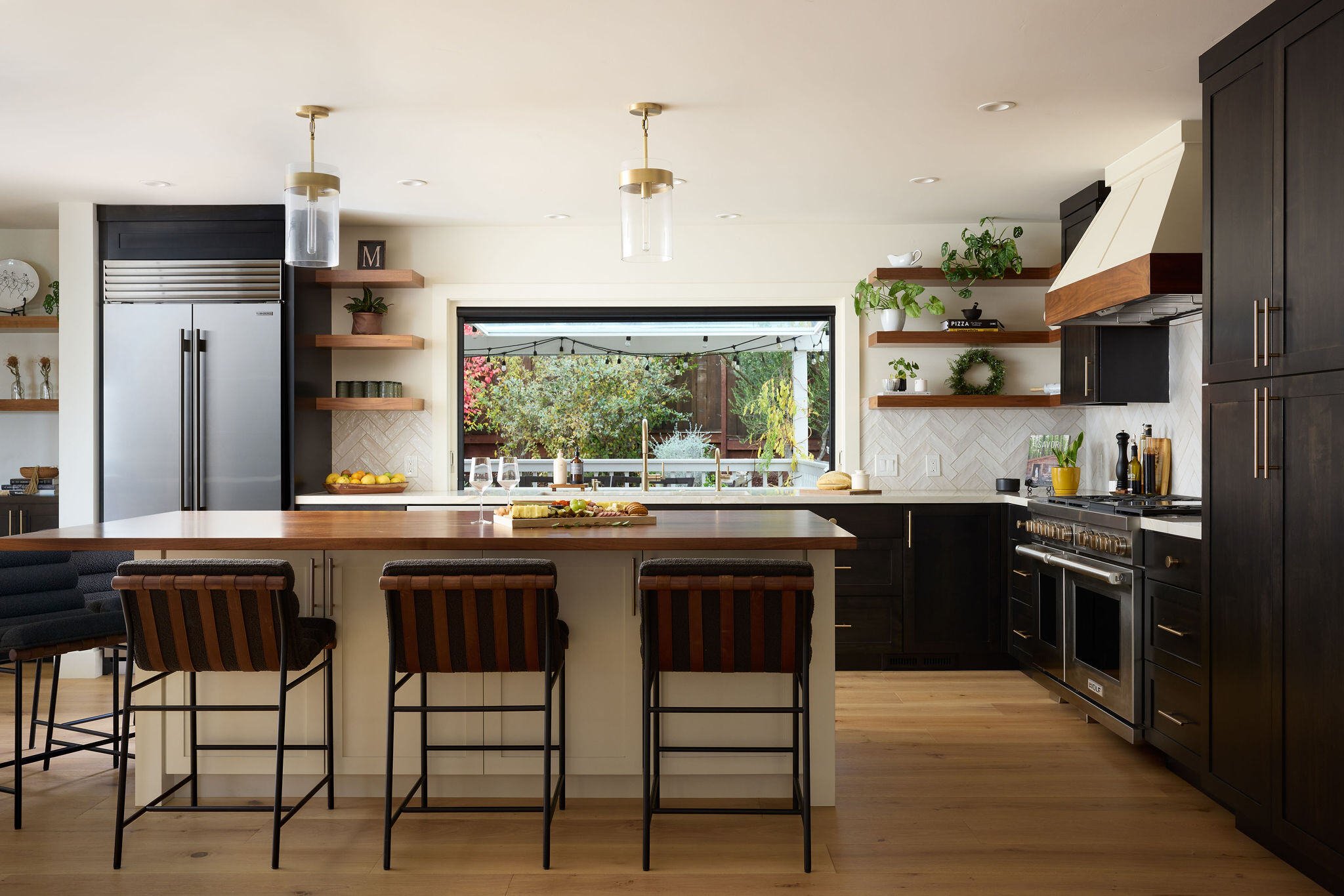 An elegant and contemporary kitchen remodel with seating for entertaining guests and a charcutier board on the island