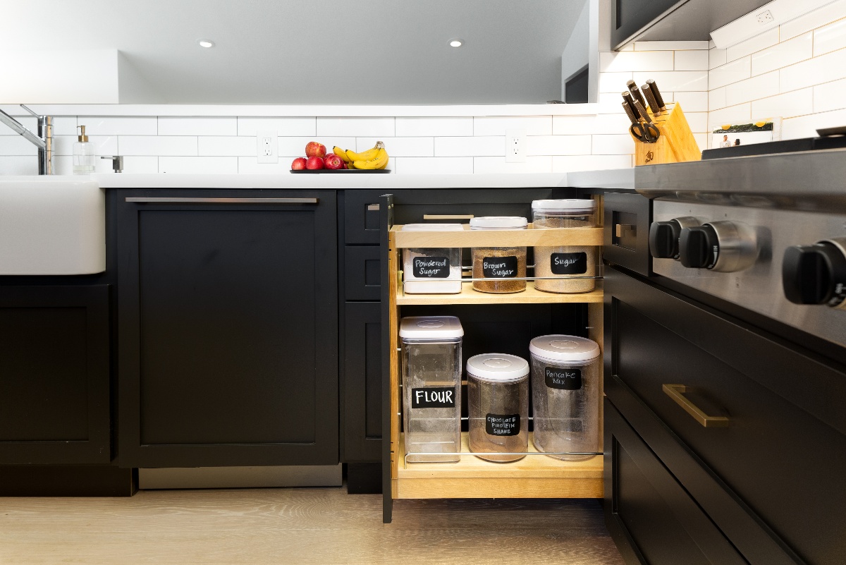sliding container storage rack built into lower black cabinets next to the range