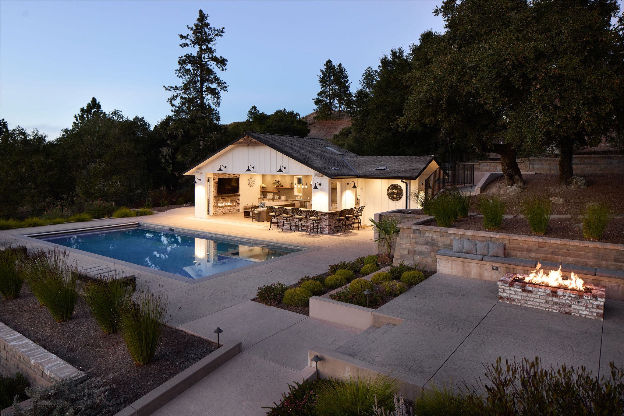 Luxurious Santa Cruz pool house with exterior lights on at dusk