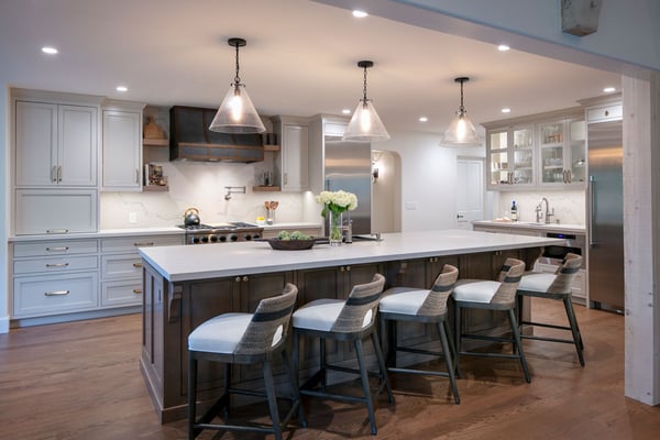 Kitchen island with 5 low bar stool chairs with backrests and can lighting