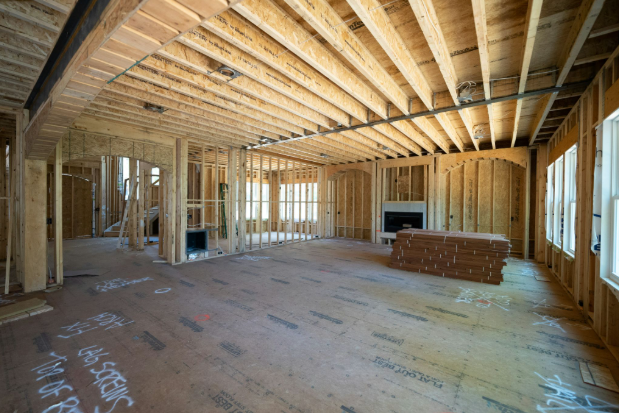 A home construction site that shows all the exposed framing and studs for finishing