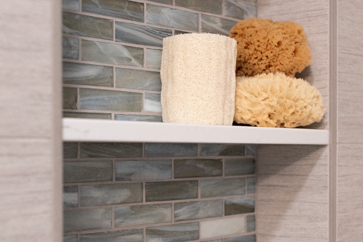 Bathroom stone shelves with ceramic backsplash and body sponges