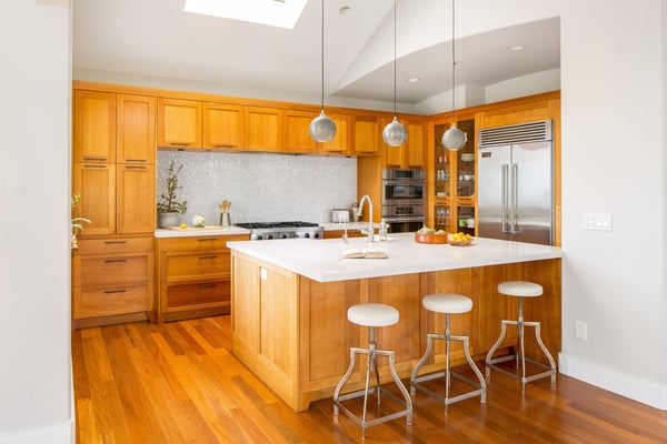 unique mosaic backsplash in a very striking kitchen remodel with lots of hardwood and storage space