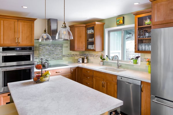 Open and airy kitchen with multiple materials used for a backsplash with stainless steel appliances