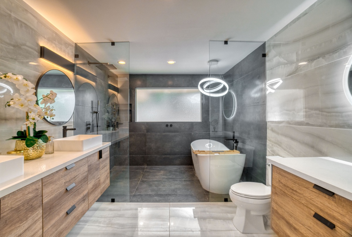 High end bathroom with marbled wall tiles, a walk-in shower, and stand alone tub