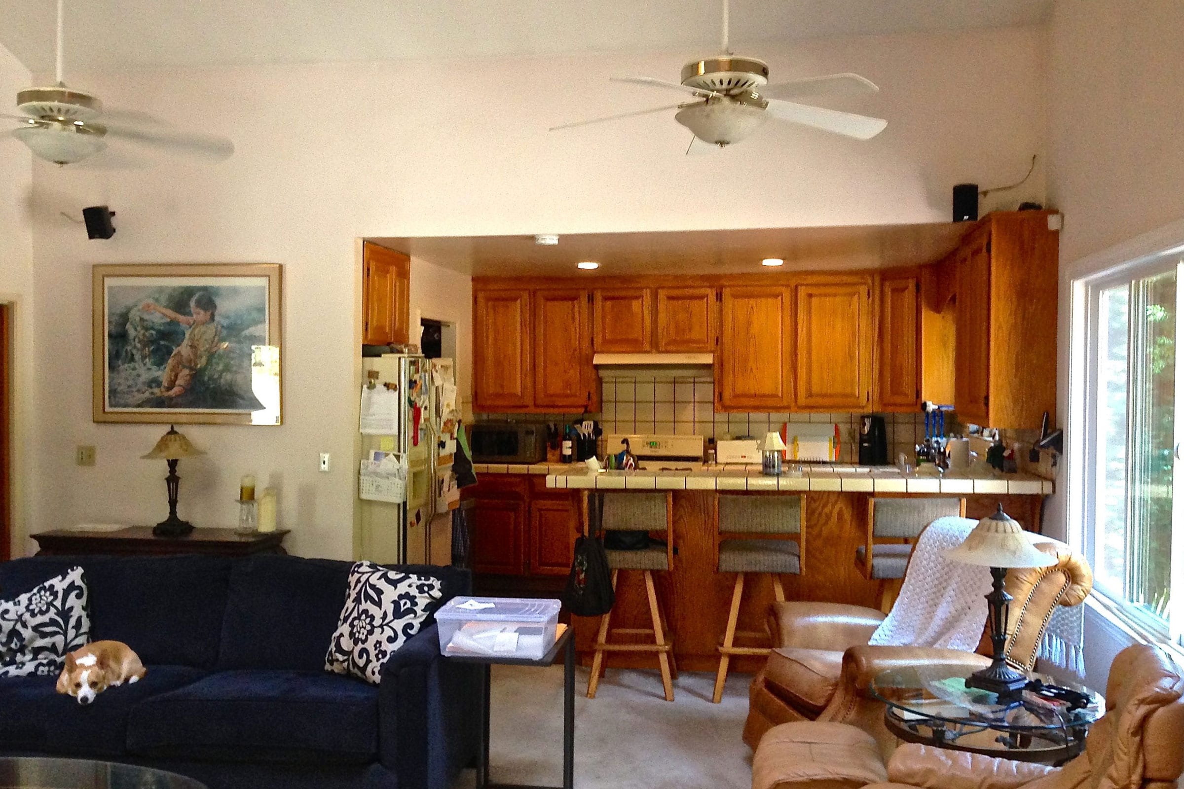 Before kitchen remodel with two ceiling fans and wooden cabinets