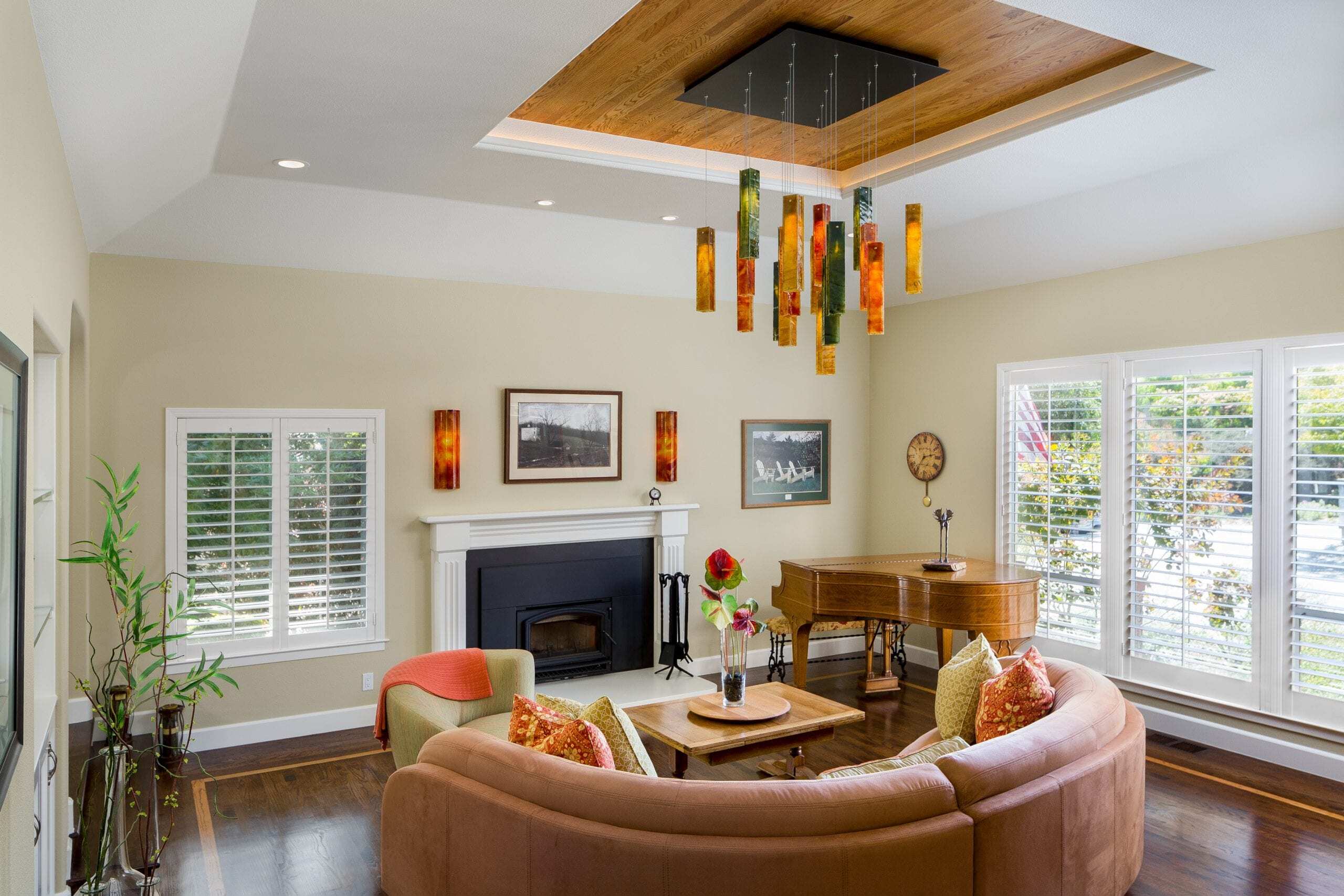 A photo of an elegant, modern, and naturally lit living room remodeling project with artistic glass hanging from the ceiling