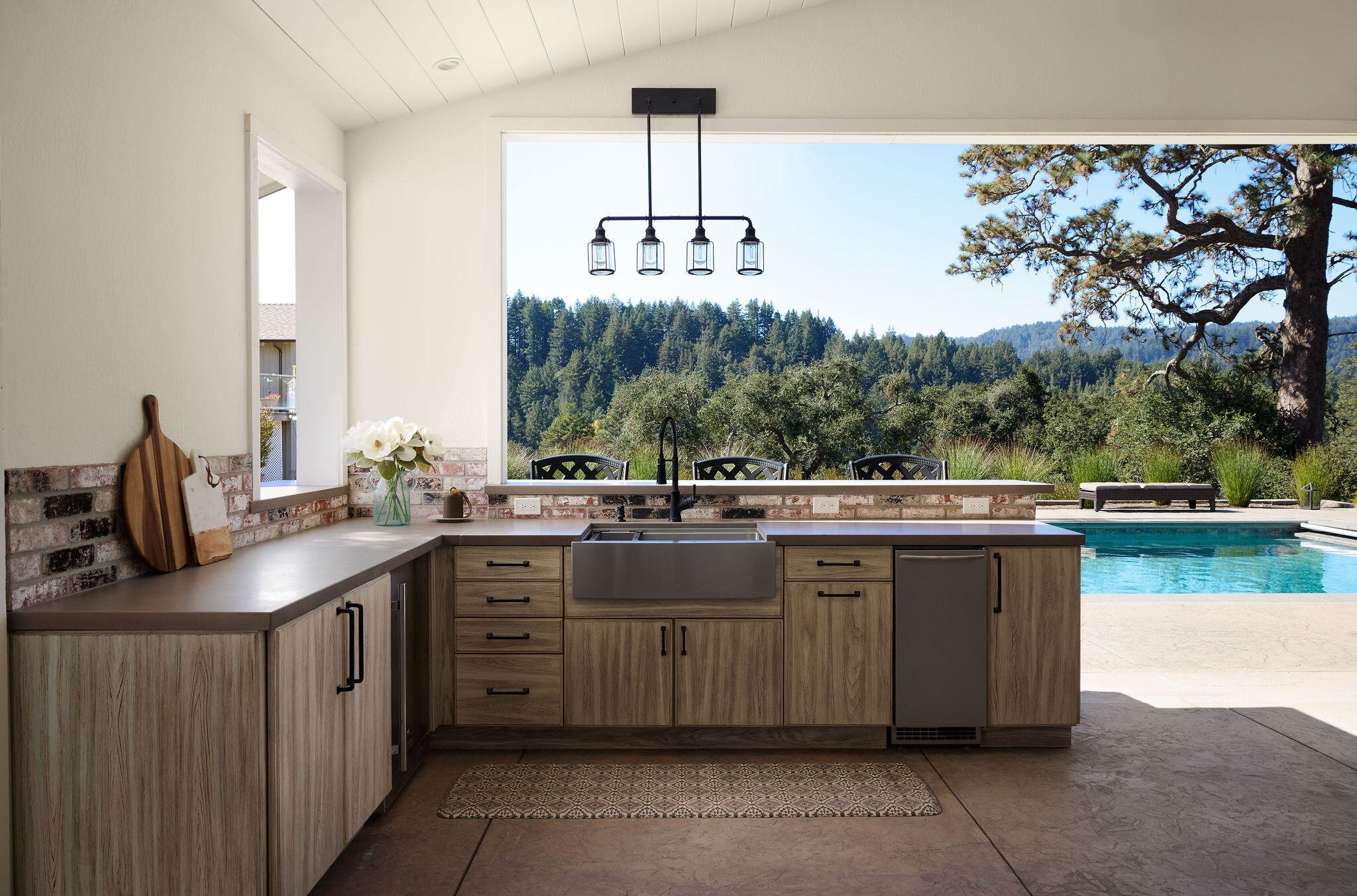 Seamless outdoor kitchen in an enclosed pool house; perfect for entertaining or relaxing under the Santa Cruz sun