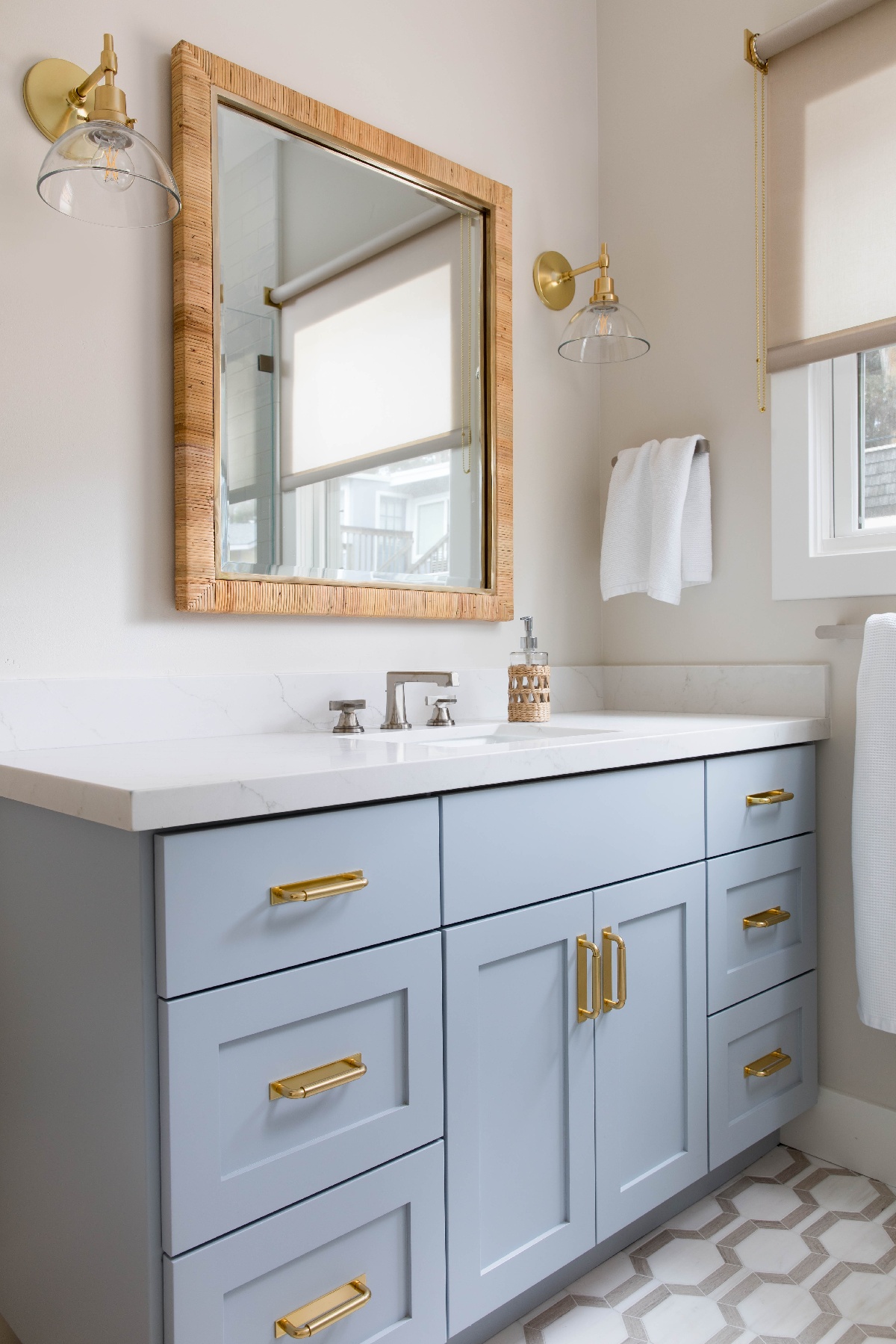Bathroom sink with blue cabinetry finish, a marble countertop, and gold finishings on the cabinet handles