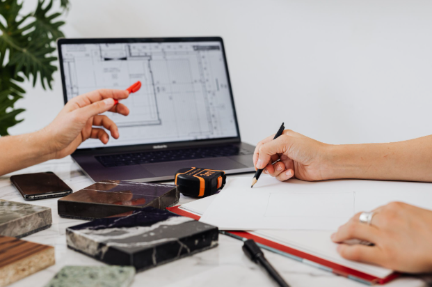 Home designer, home builder, and a home owner discussing plans with one another
