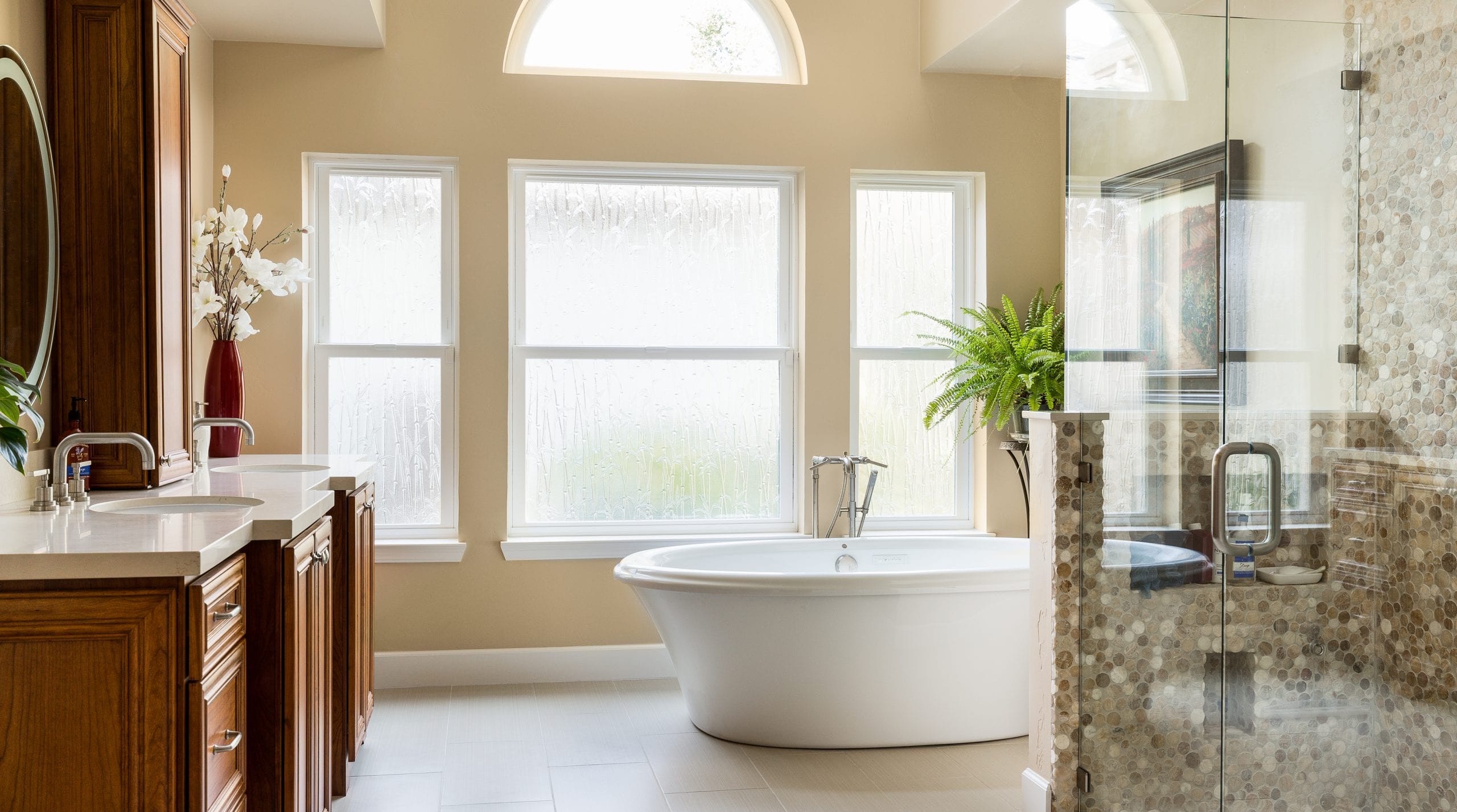 Stand alone tub in very open bathroom with 4 large windows allowing natural light to pour into the space.
