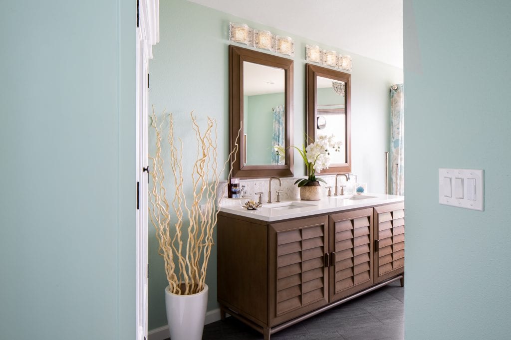 Dual vanity bathroom with a teal wall color and dark wood finishes