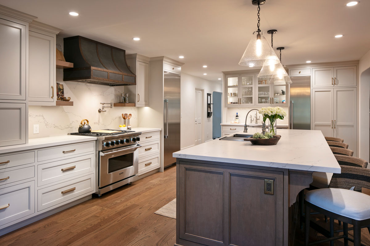 Luxurious home kitchen remodeling project with stainless steel appliances, a kitchen island with pendant lights, and high-quality wooden floors