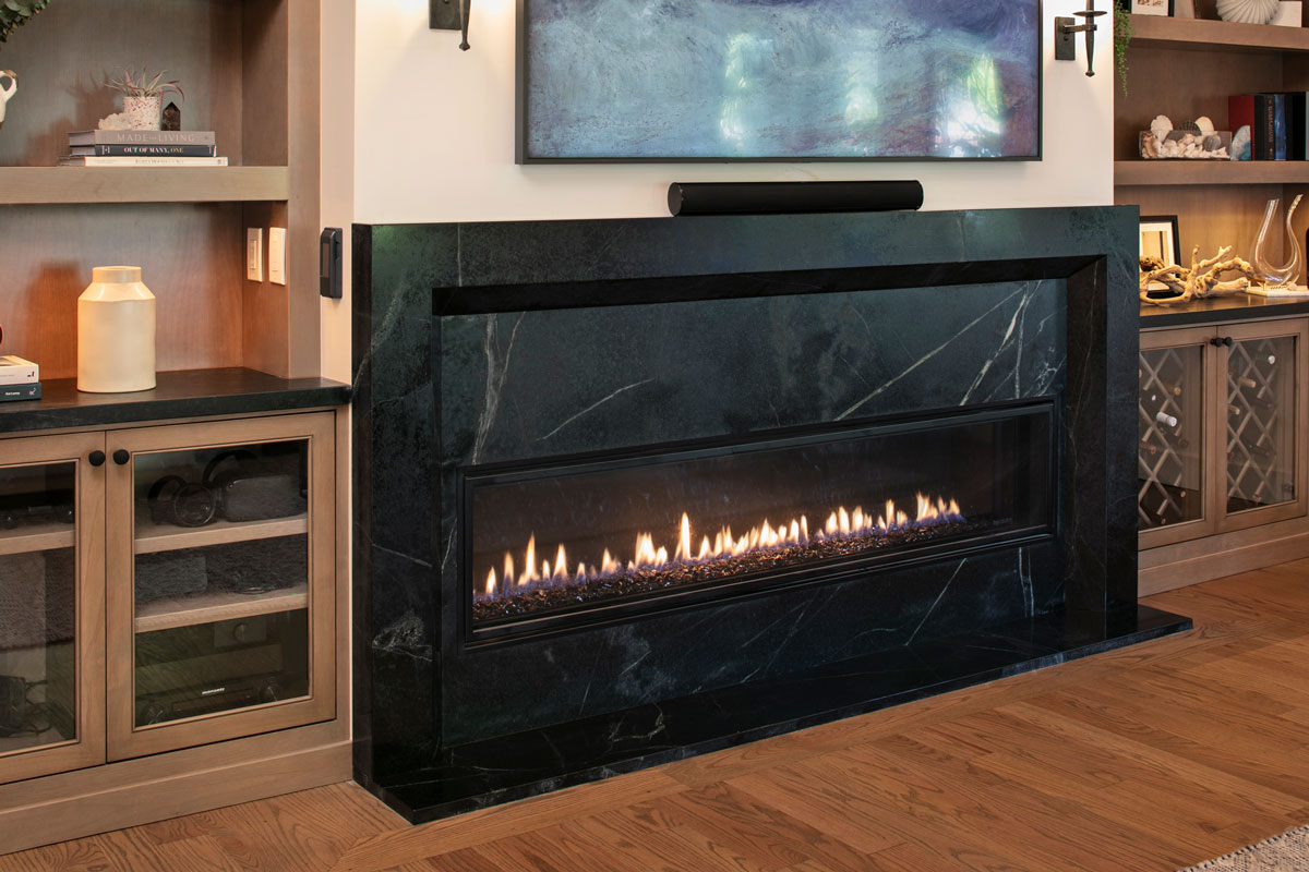 Black stone fireplace with wooden cabinets