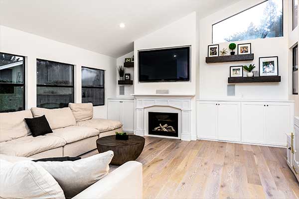 Living room with white leather couch, a fire place, and wall mounted television