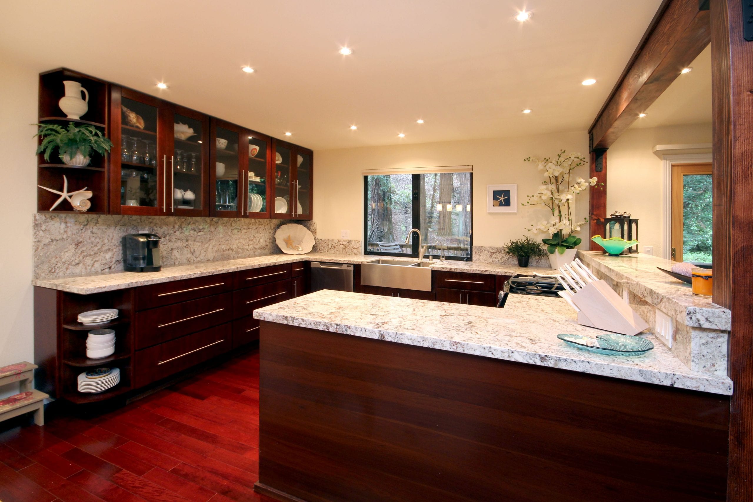 Kitchen with white and grey granite countertop and dark wood finished cabinets