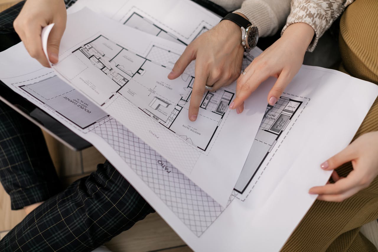 A homeowner going over architectural plans for their home as they plan to build up or out in their home addition