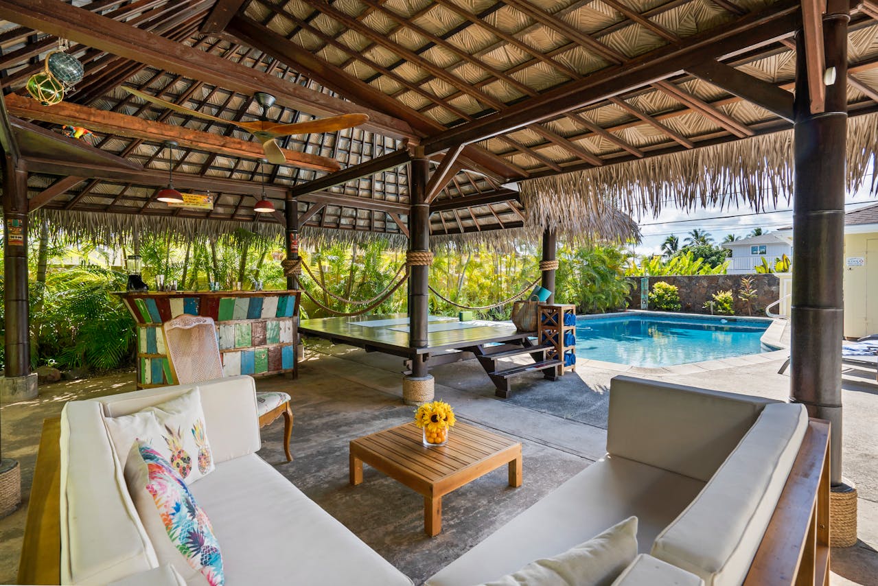 luxurious outdoor living space with a cabana, pergola for lots of shade, outdoor seating, and an in-ground pool to enjoy the California sun