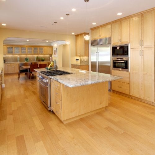 Fresh kitchen remodel with lightwood cabinetry and flooring with granite countertops