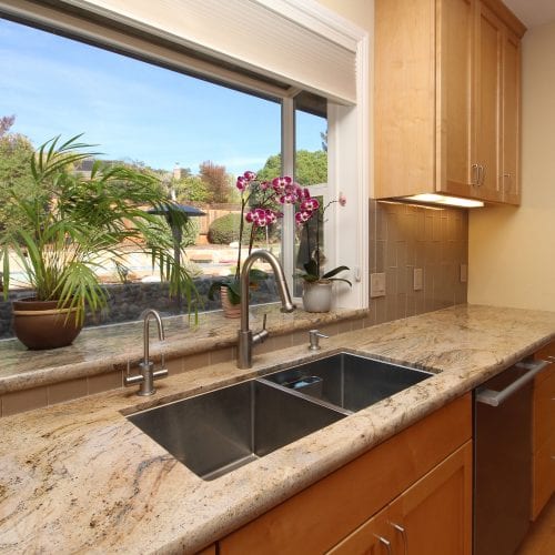 Embedded kitchen sink  in front of a window to let in natural light