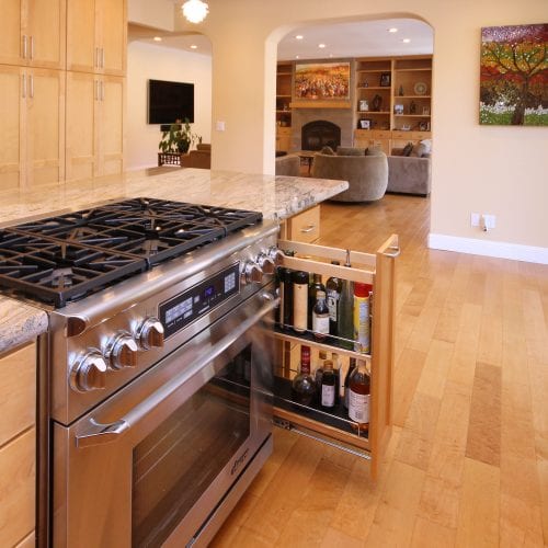 Stainless steel stove and over with sliding storage cabinet on the right