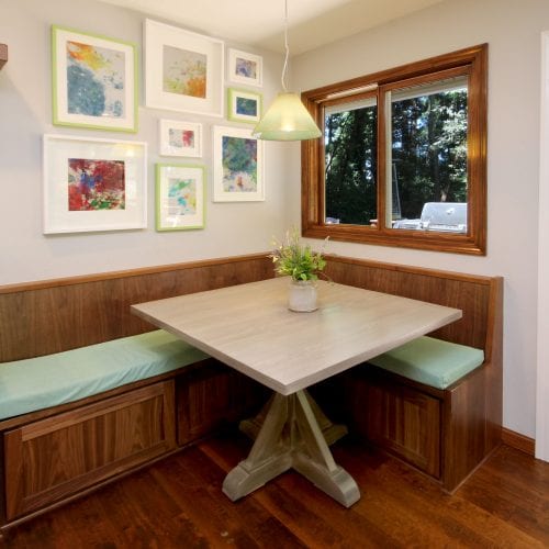 Corner table seating with teal upholstery and square, white table