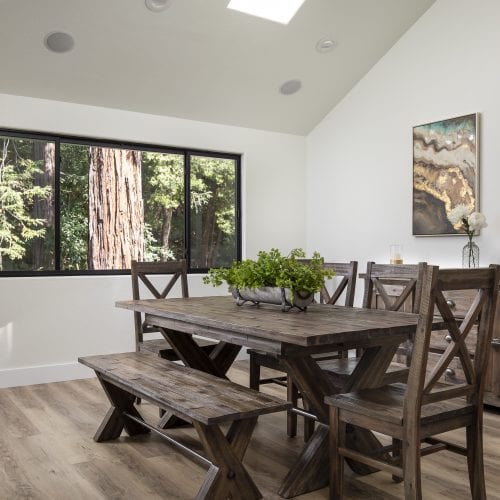 Wooden dining room table with bench seating and several chairs