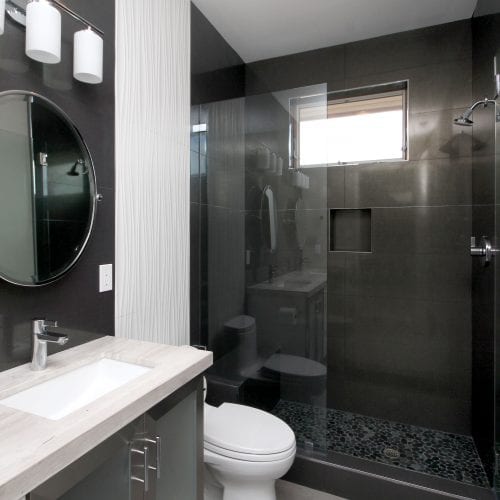 Black tile walk-in shower with window to let in natural light