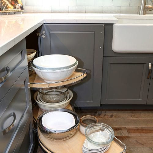 Retractable storage cabinet full of glass and ceramic bowls