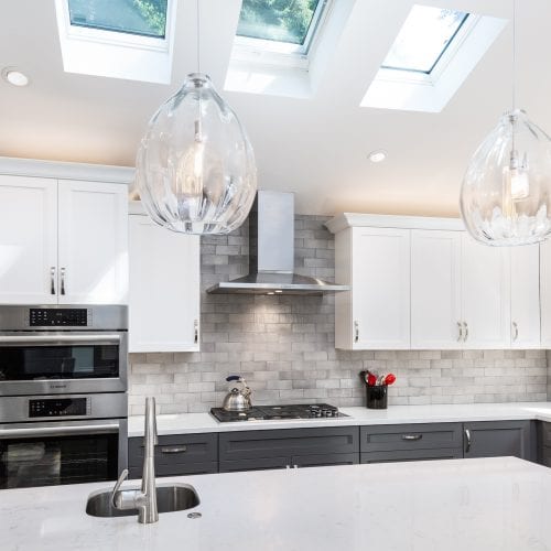 Hanging glass lamps over a white kitchen island