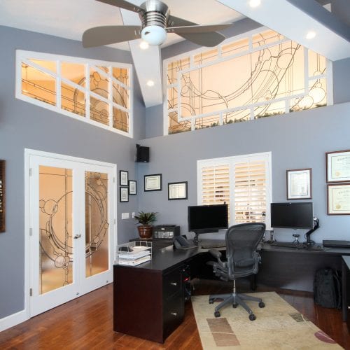 Home office with stenciled glass windows and high ceiling