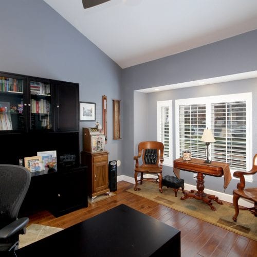 Office with wooden chairs and table in front of a window