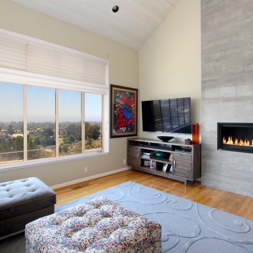 Living area with mounted TV and stone fireplace