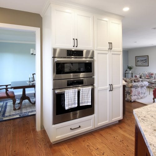 White cabinets with two ovens embedded in