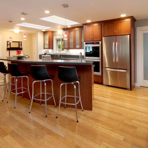 Kitchen with red wood island and black leather chairs