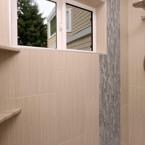 Shower with waterfalled tile, sliding window, and two shelves