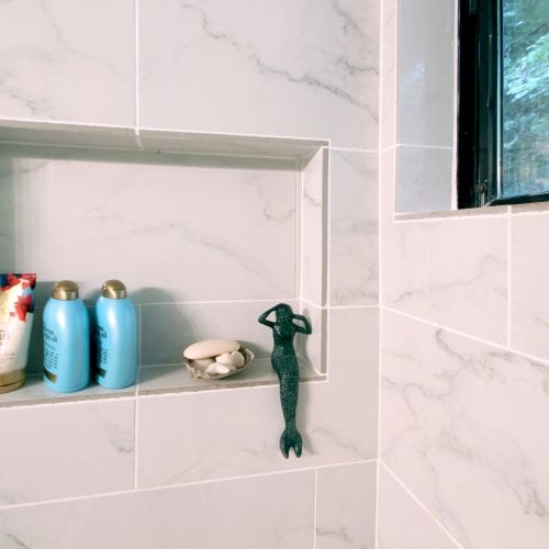 Shower shelf with a green mermaid figuring seated upon