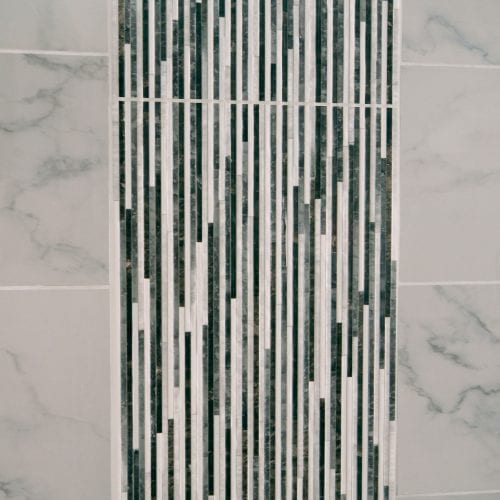 Shower tiling with a grey and white cascading effect