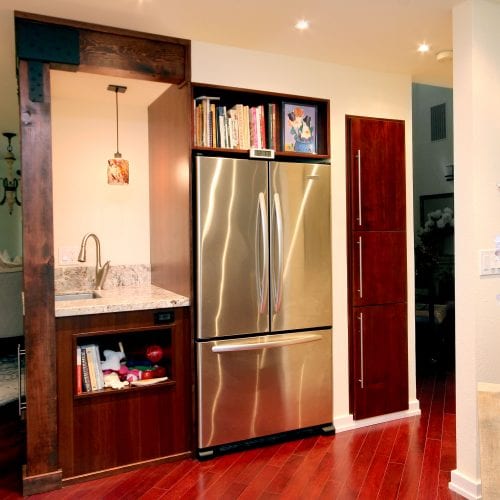 Kitchen with cherry wood flooring and stainless steel appliances