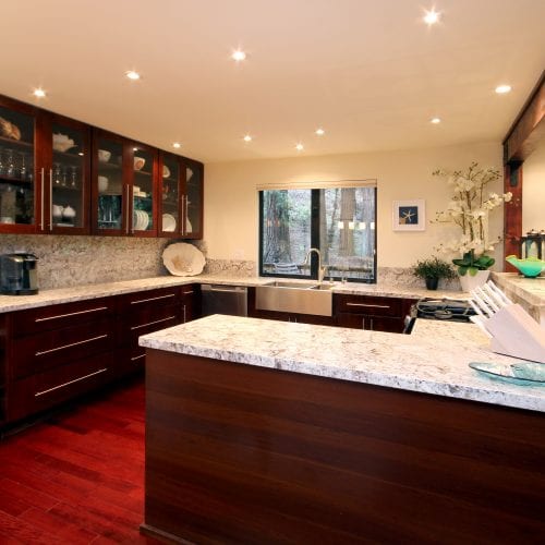 Finished wooden cabinets and cherry wood flooring with granite countertops