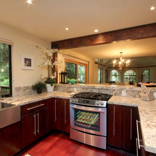 U-shaped kitchen counter with granite countertops and stainless steel oven