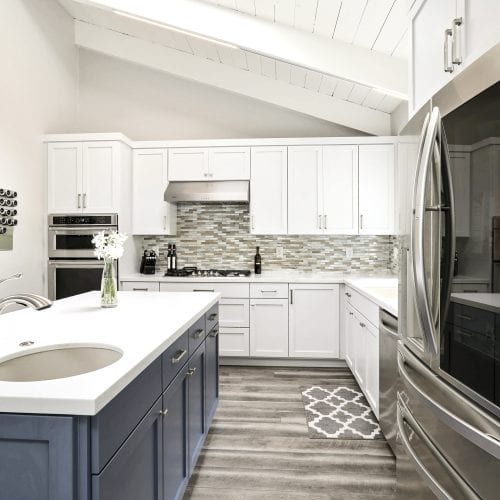 Kitchen with grey hardwood floors, and stripped diamond pattern rug