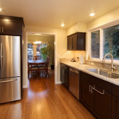 Kitchen entryway leading to dining room with refrigerator on the left