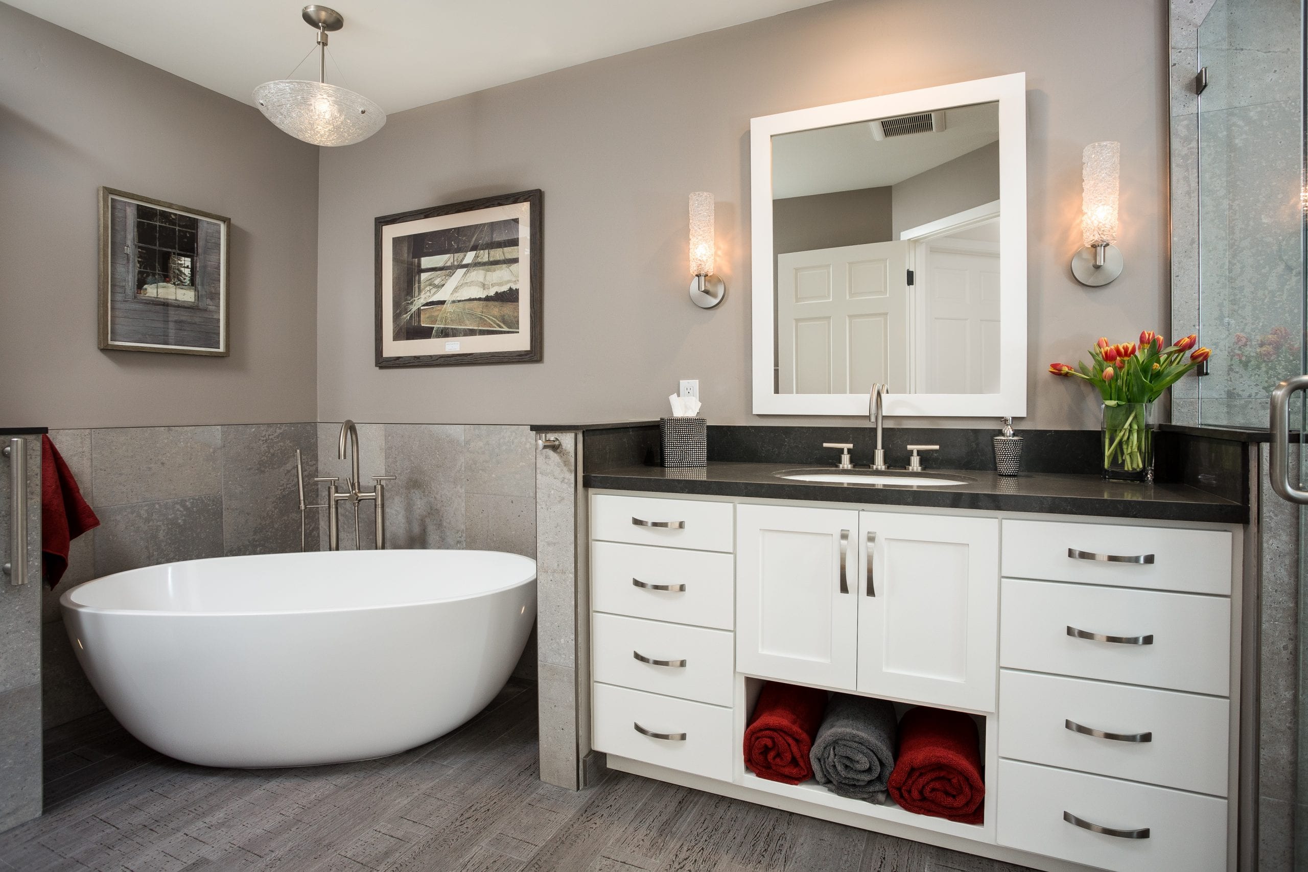 Ceramic tub next to counter with white wood cabinets