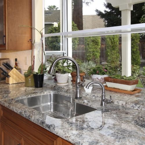 Stainless steel sink embedded into granite countertop