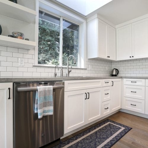 Stainless steel dishwasher with blue, white, and grey towel