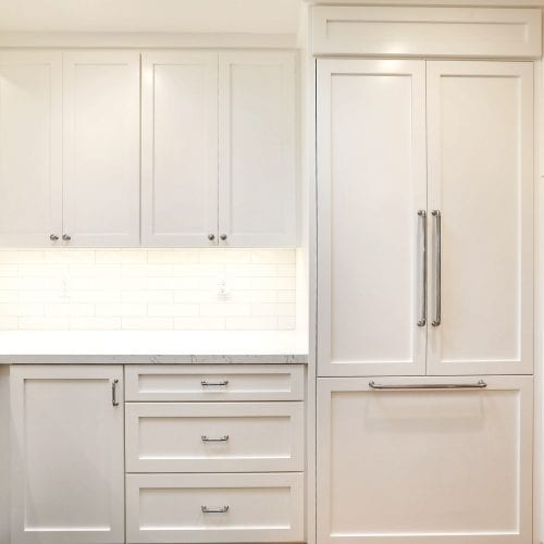 White wood kitchen cabinet storage with tile backsplash cut-out