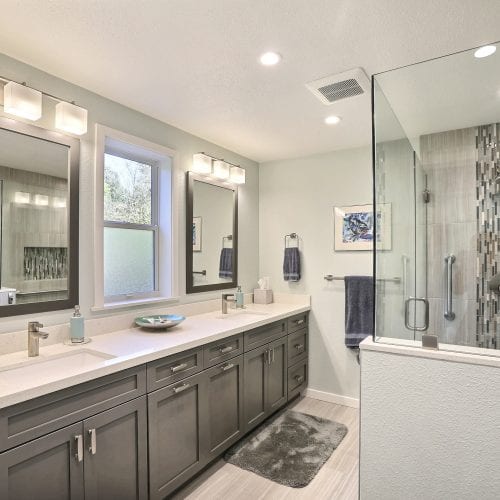 Glass shower door with white tile finishes enter into bathroom