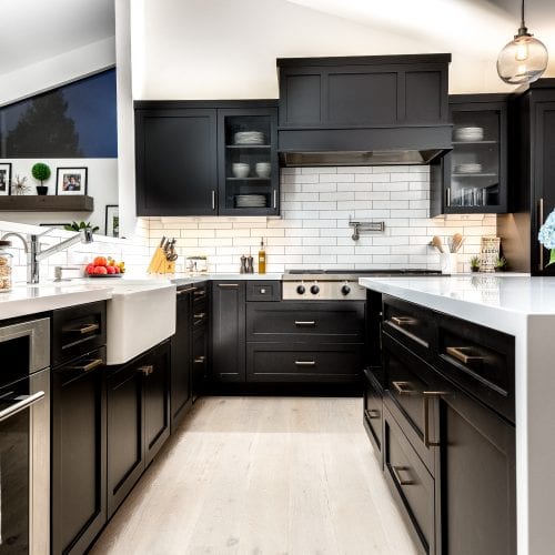 Kitchen with black cabinetry and white tile backsplash