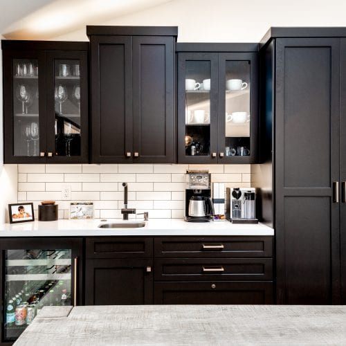 Black cabinets with white countertop and a mini refrigerator